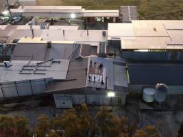 Aerial view of activists on roof of slaughterhouse - Activists shut down Benalla Slaughterhouse, with massive Stop Gassing Pigs for Pork banner on rooftop - Captured at Benalla Abattoir, Benalla VIC Australia.