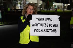 Cedar Meats Vigil - National Week Of Action 2025 - During the Shut Down Slaughterhouses Week of Action, we held a vigil outside of the Cedar Meats slaughterhouse in Brooklyn, Victoria.
During a two week investigation last year, our hidden cameras captured the handling and slaughter of animals, including newborn lambs and kids born in the holding pens of the slaughterhouse.
It was a Wednesday night when we gathered outside the slaughterhouse, holding signs and listening to music and speeches from investigators. We wanted to send a message to Cedar Meats, to let them know that we have not forgotten how they treat animals when they believe that no one is watching
We poured fake blood across their driveway as a visual reminder to everyone passing by, that animals arriving here are coming to their deaths. At the gates to the slaughterhouse, we each left a flower.
The images of animals whose deaths we have seen will haunt us forever, but we are determined to continue to fight in their name. - Captured at Cedar Meats, Brooklyn VIC Australia.